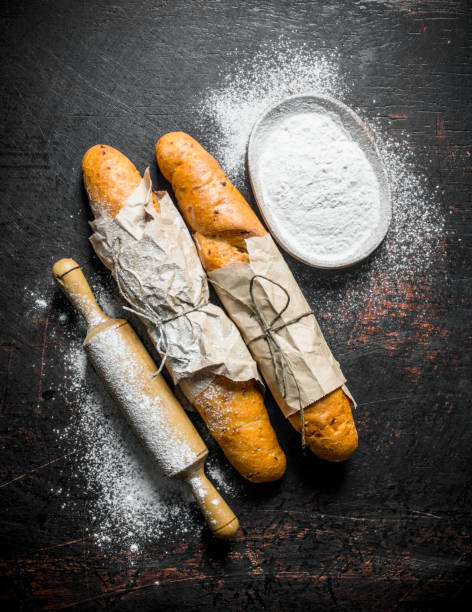 istock Fresh French baguette with flour and rolling pin. 1145476355