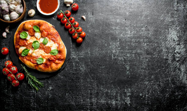 istock Homemade pizza with cherry tomatoes, spinach and garlic. 1145476459
