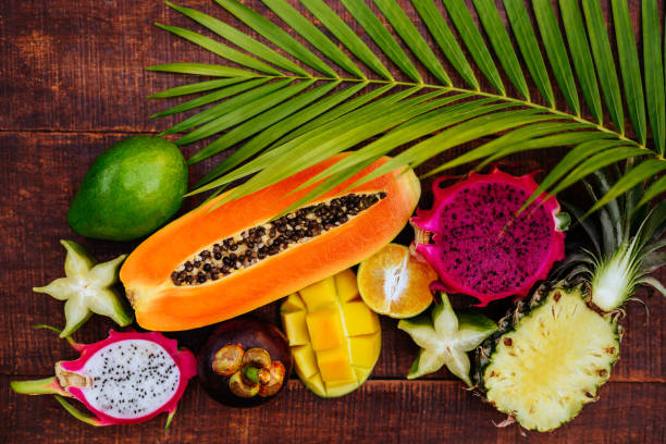 istock Tropical fruits on wooden background 1145477621
