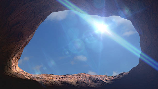 istock cave entrance, mysterious den opening with blue sky 1145478022