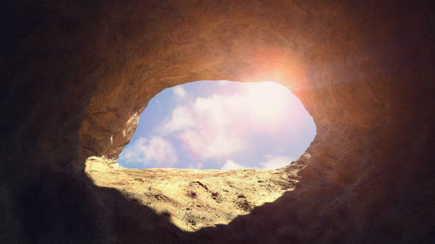 istock cave entrance, mysterious den opening with blue sky 1145478807