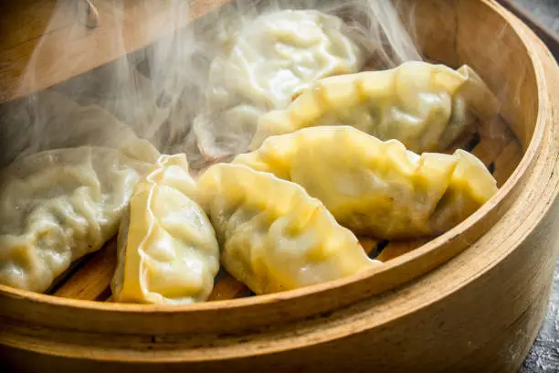 Hot Chinese dumplings gedza in the steamer. Traditional dish