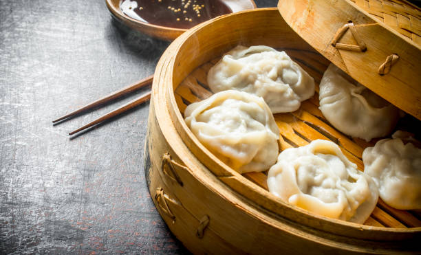 istock Hot aromatic manta dumplings in bamboo steamer with soy sauce. 1145481222