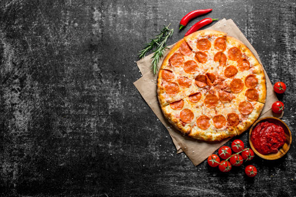 istock Pepperoni pizza with chili, rosemary and tomatoes. 1145481400