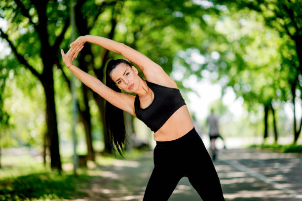istock Women stretching arms in public park 1145482011