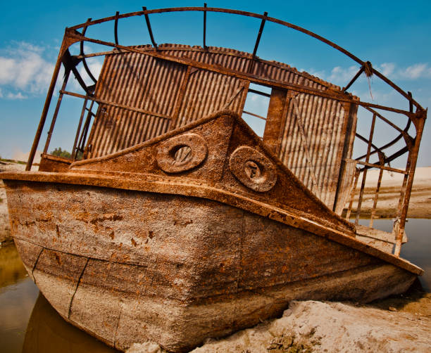 An abandoned damaged metallic boat with blue sky background unique photo