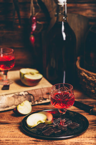 Homemade red currant nalewka and chocolate with apple Homemade red currant nalewka and chocolate with sliced apple on metal tray nalewka stock pictures, royalty-free photos & images