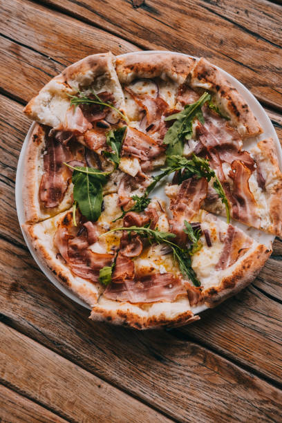istock Overhead pizza carbonara on rustic wooden table 1145489238