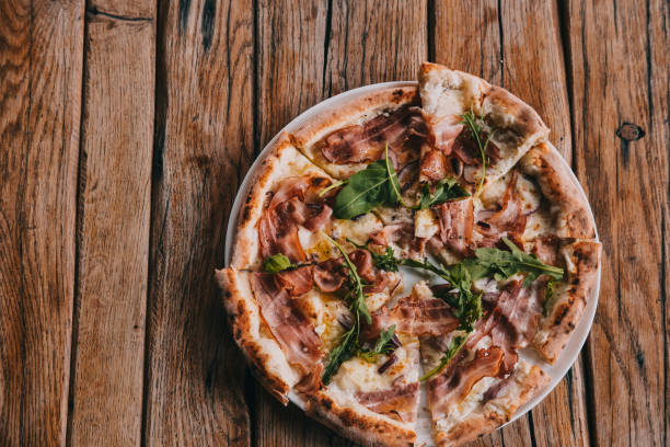 istock Overhead pizza carbonara on rustic wooden table 1145489245