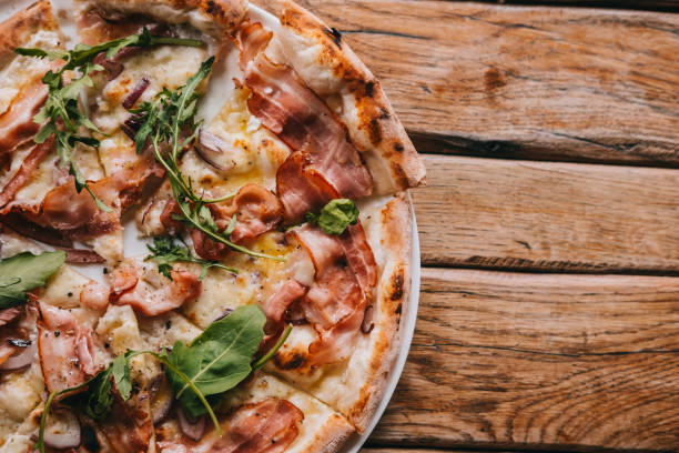 istock Overhead pizza carbonara on rustic wooden table 1145489248