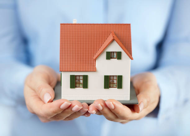 istock Model of house in women's hands 1145491891
