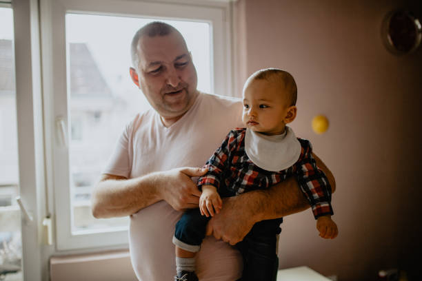 istock Father holding his baby boy at home 1145494381