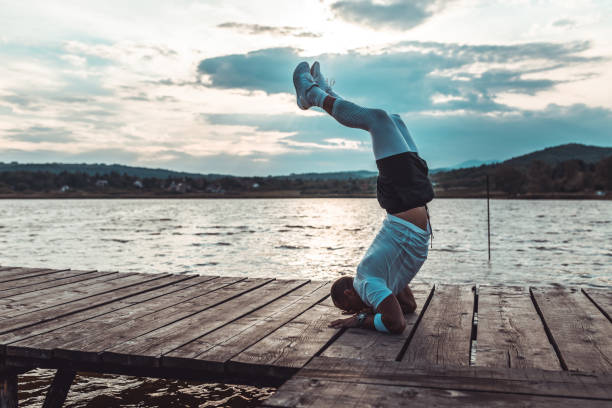 istock Man exercising and doing handstand outdoors in nature 1145497197