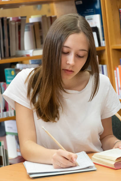 istock Teenage girl studying in a library 1145497246