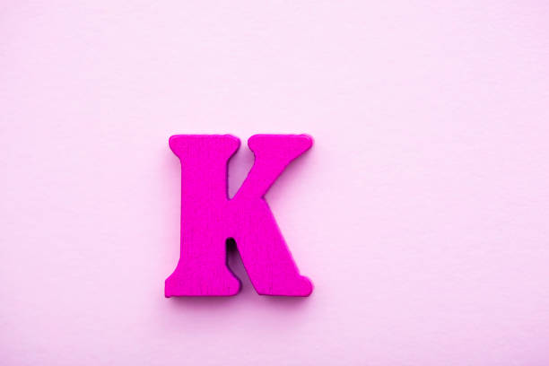 istock Wooden letter K on pink background. 1145497482