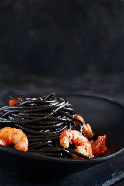 istock Squid ink pasta with prawns and tomatoes 1145497654