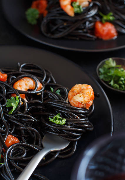 istock Squid ink pasta with prawns and tomatoes 1145497658
