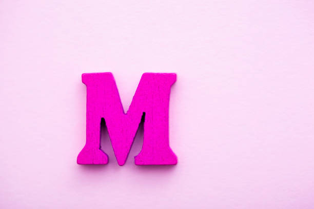 istock Wooden letter M on pink background. 1145498268