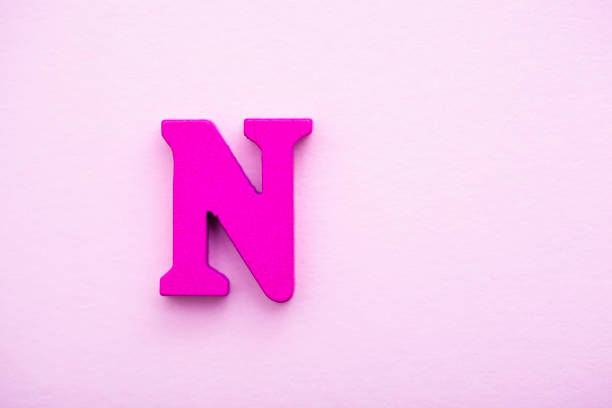 istock Wooden letter N on pink background. 1145498402