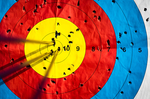 Close up on three arrows in the middle center of the target goal achieved success archery