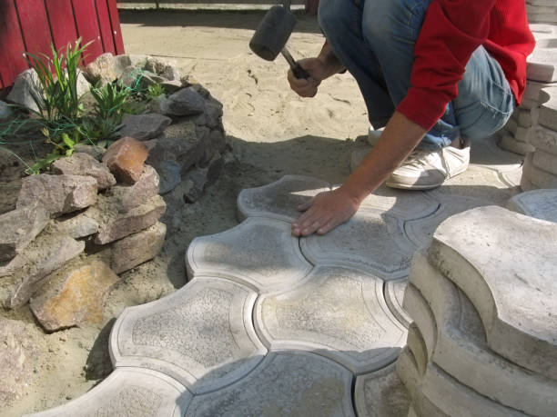 el hombre hace el trabajo de la colocación de losas de pavimentación con un mazo en el patio - rubber mallet fotografías e imágenes de stock