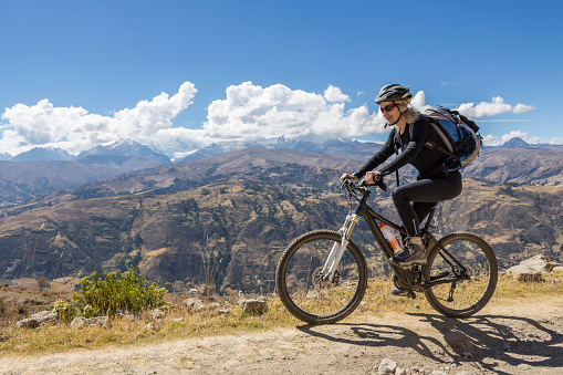 A female mountainbiker is riding high above the city of Huraz which is the capital of the Ancash Region. Huaraz is the main destination for winter sports and adventure. Many visitors from around the world come to the city for practicing sports as climbing, hiking, mountain biking and snowboarding, and also to visit the glaciers and mountains of the Cordillera Blanca, mainly Mount Huascarán, which is considered the tallest mountain in tropics, all of them located in Huascarán National Park which UNESCO declared a nature world heritage site.\nCanon EOS 700D, 1/500, f/5,6 , 18 mm.