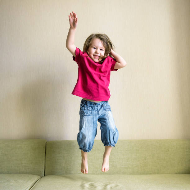 istock Funny three-year-old child jumps on couch 1145505662
