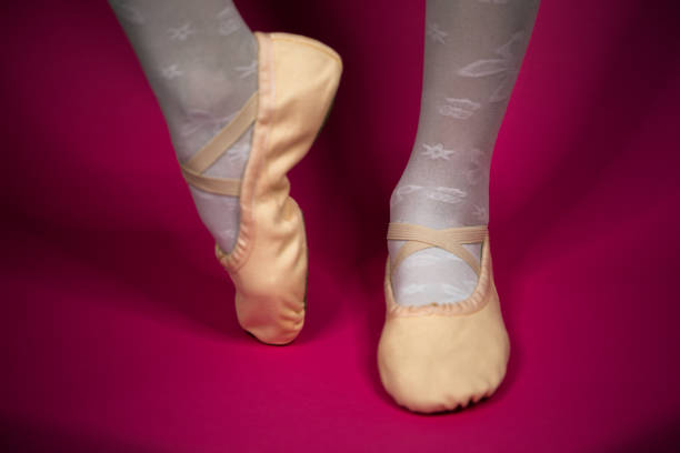 istock little ballerina's legs in pointe on a pink background. ballet position