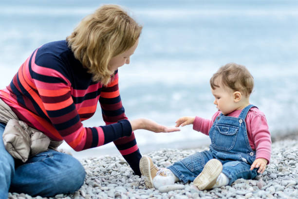 istock Baby with mother playing on the beach 1145518913