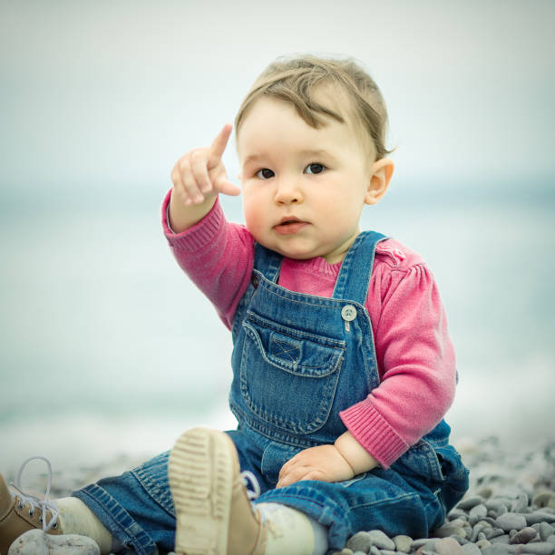 istock Cute baby sits on the beach 1145519001