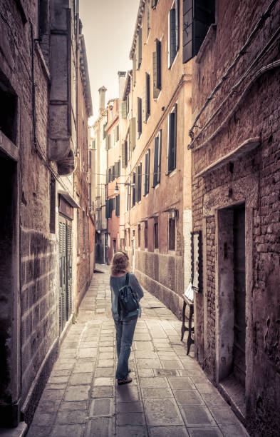 ガールツーリストは、ヴェネツィア、イタリアの狭い通りにあります - european culture architecture vertical venice italy ストックフォトと画像