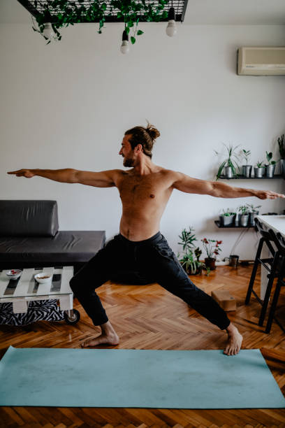 istock Young man doing yoga at home 1145531339