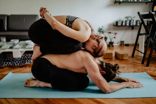 Boyfriend and girlfriend practicing acroyoga at home