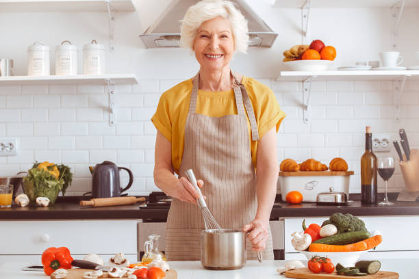 istock Handsome grandma cooking veggie dinner, toothy smiling 1145532317