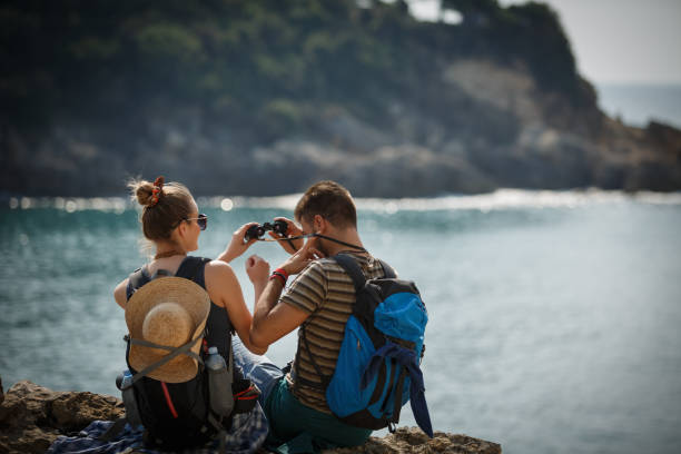istock Young couple watching nature through binoculars 1145532370