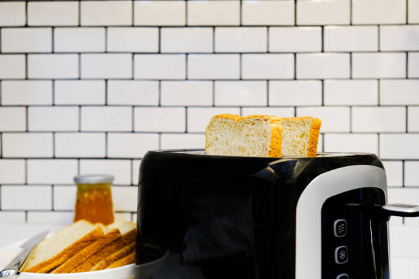 istock Whole wheat bread on Toaster with orange jam Bottle for healthy breakfast at home white brick wall background 1145563092