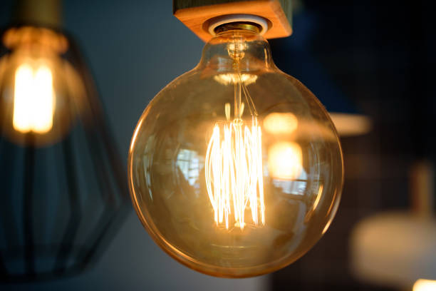 istock Vintage style light bulb hang in darkness 1145565154