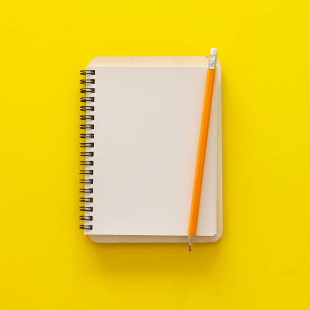 istock blank notebook over yellow background. ready for mockup. Top view flat lay 1145568560