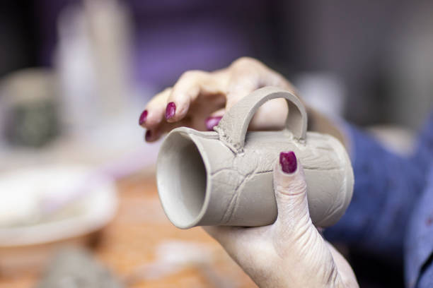 istock Hands of artist who make a mug from ceramic clay in studio 1145570027