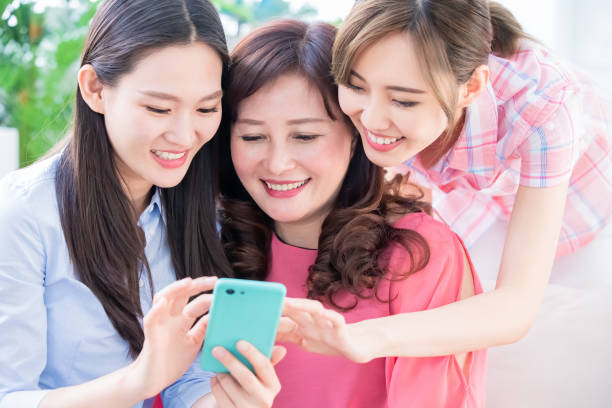 istock Daughters show mobilephone to mom 1145573852