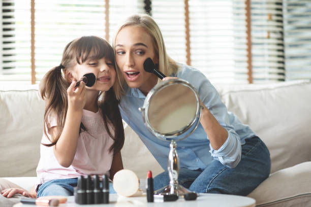 Mom and Daughter applying cosmetic with brushes.