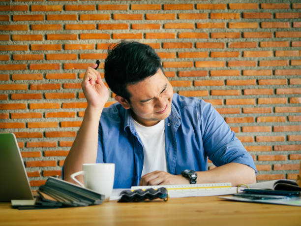 istock Seriously Asian architecture or engineer working in office with laptop, lifestyle concept.  Brick wall background. 1145578782