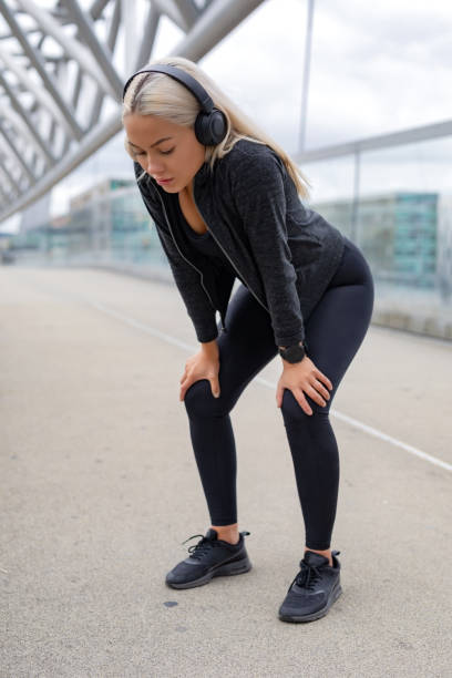 istock Tired Woman Resting With Hands On Knees After Running Workout 1145578816