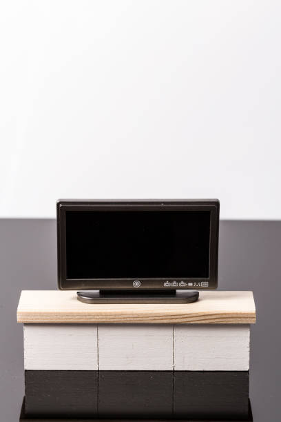istock LCD flat tiny toy television on a white furniture over a black and white background 1145581777