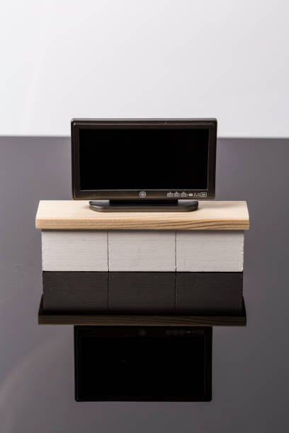 istock LCD flat tiny toy television on a white furniture over a black and white background 1145581845