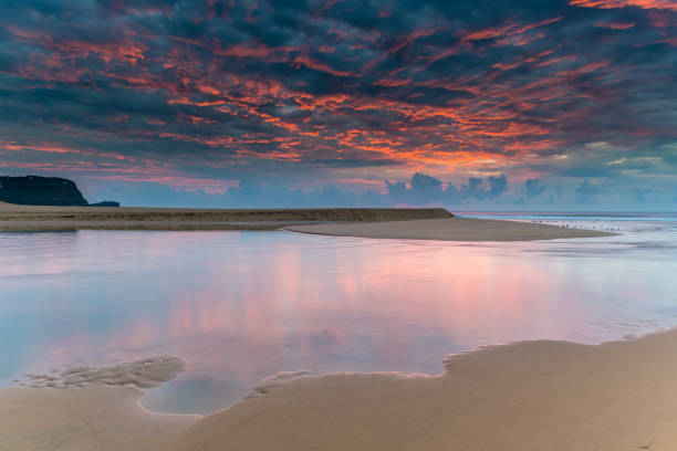Sunrise Lagoon Waterscape with Vibrant Cloudy Sky Sunrise Waterscape from Avoca Lagoon on the Central Coast, NSW, Australia. avoca beach photos stock pictures, royalty-free photos & images