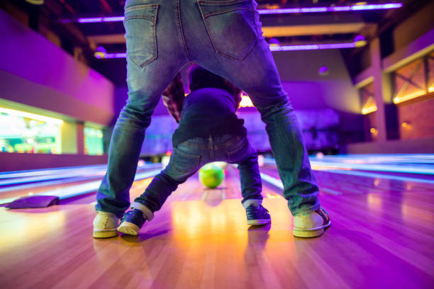 Father and son at bowling alley Father and son at bowling alley leaning photos stock pictures, royalty-free photos & images