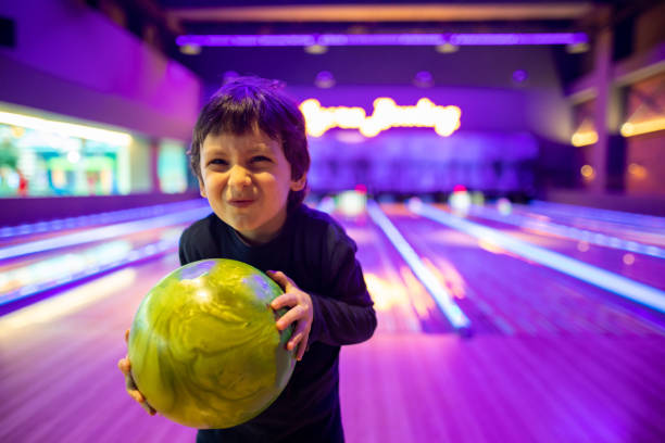 Portrait Cute child with ball in bowling club stock photo