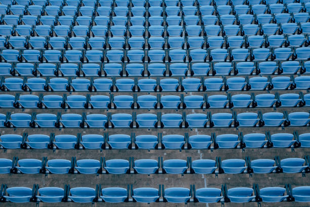 Symmetric shot of empty seats at a ball park on a sunny day.