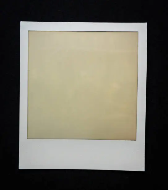 Photo of old empty instant film frame on real paper background